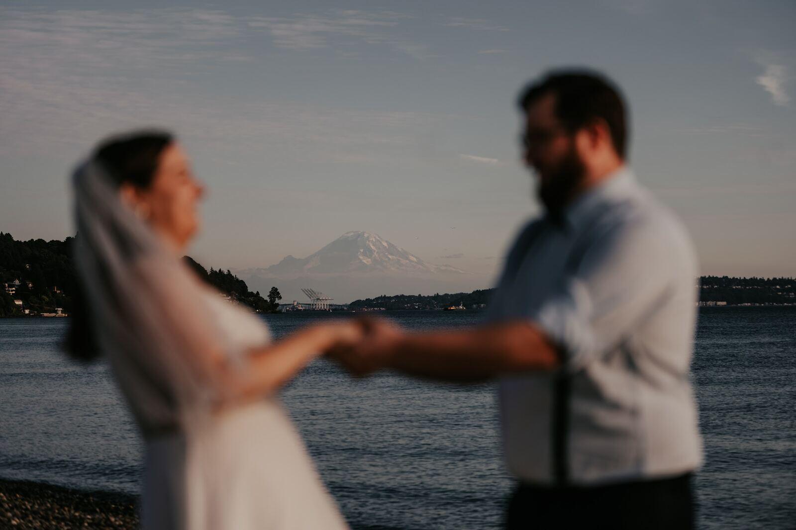 A couple meeting for their first look on a mountain trail, Mount Rainier behind them
