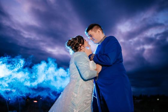 Couple wrapped in drifting blue smoke