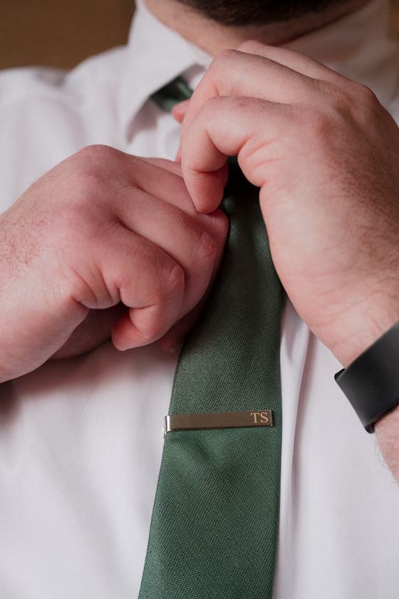 Hands straightening a tie before the ceremony