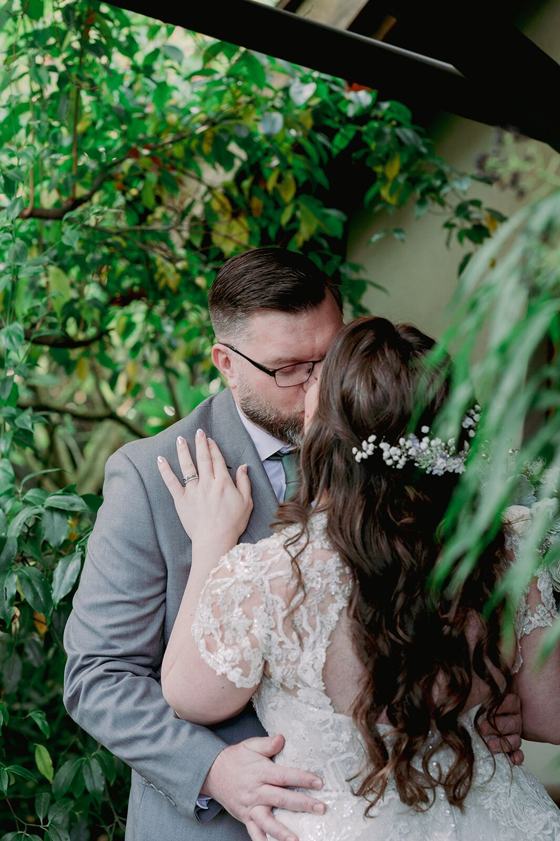 Kiss beneath a flowering garden arbor