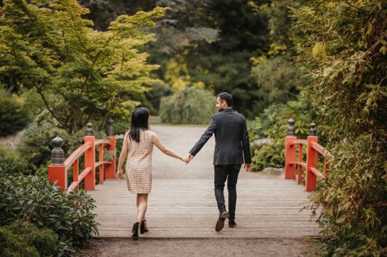 Couple walking across a garden bridge