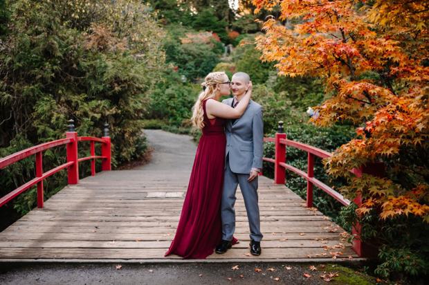Couple embracing on the red moon bridge at Kubota Garden