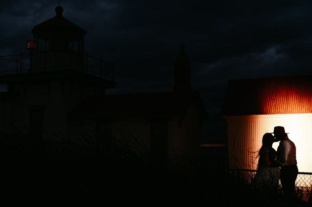 Lighthouse glowing at dusk on a Puget Sound beach