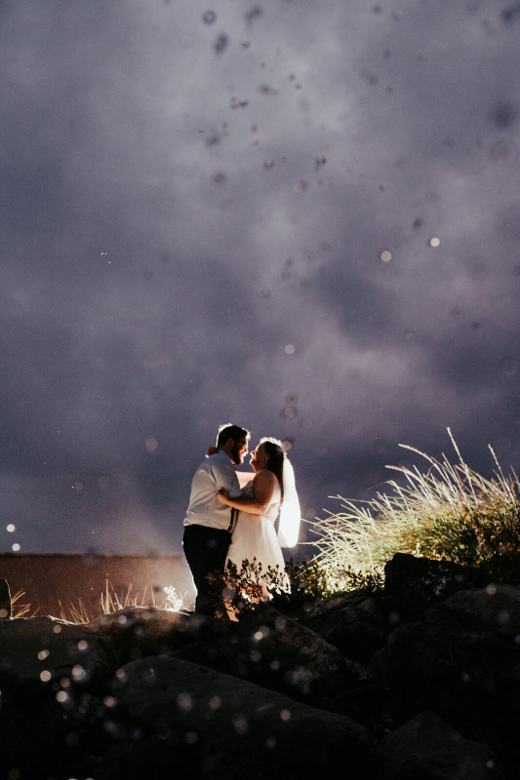Couple lit by sparks under a night sky