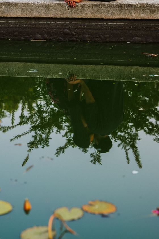 Couple reflected in the still surface of a pond