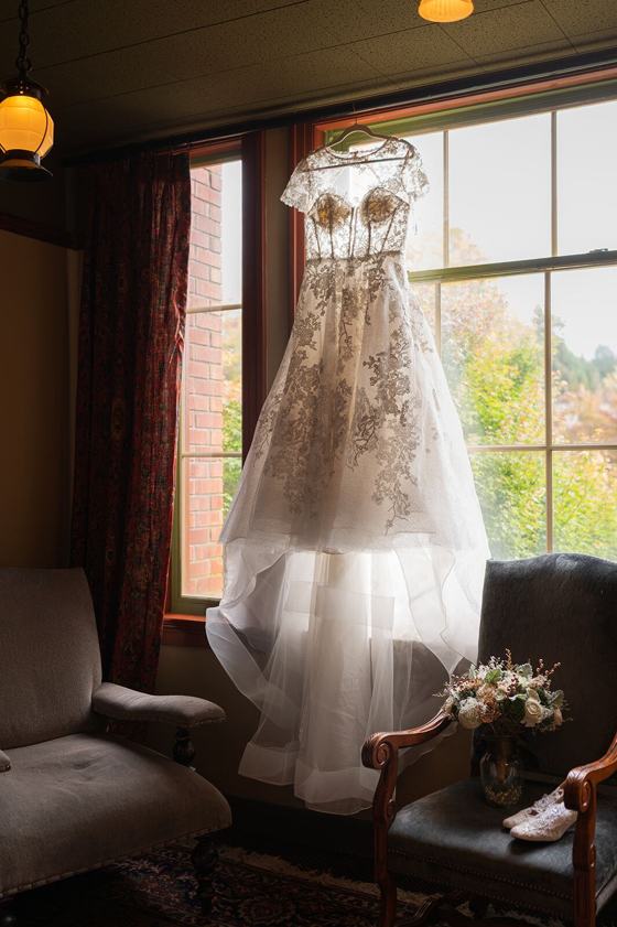Wedding dress hanging in soft window light