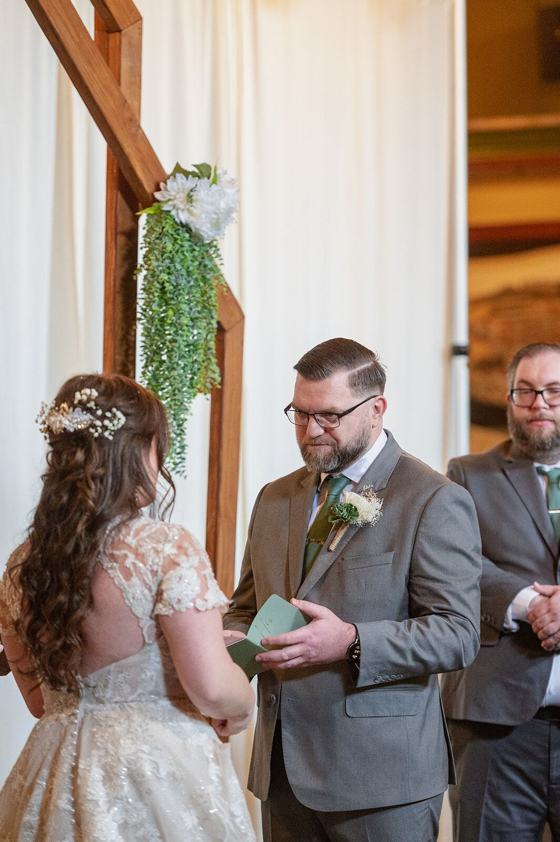 A couple reading their vows aloud to each other